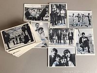 Black and white Beatles collector cards with printed band member signatures and group poses laid out on surface