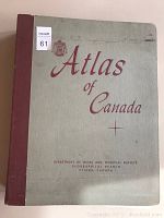 Front cover of large format hardbound 'Atlas of Canada' with title and Department of Mines and Technical Surveys text, showing green cover and red cloth spine