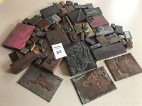Full assortment of approximately 65 printing blocks in various sizes and designs on a flat surface