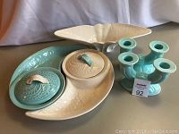 Full view of the set consisting of two combo serving dishes (one blue with lid, one white) along with two blue ceramic candlesticks.