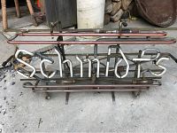 Front view of antique Schmidts neon beer sign on a concrete floor showing neon tubes and metal frame.