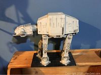 Full side view of the entire AT-AT Walker model mounted on a black display plate, showing overall size and shape.