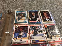 Close-up photo of several Wayne Gretzky hockey cards in sleeves inside a binder showing different card designs and years