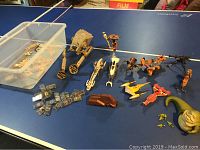 Overview top-down photo showing multiple Star Wars miniature ships and vehicles along with scattered Comtech chips and a large green figure.