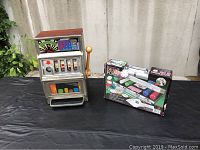 Photo of the Casino King slot machine and Deluxe Poker Set box on a table.