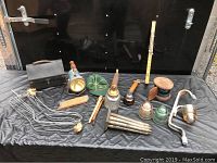 Overview of the 14-piece vintage and antique collectables including tools, textiles, glass insulators and lunchbox.