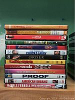 Photo showing spines of 13 DVD cases stacked horizontally with titles visible.