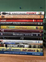 Photo showing stack of 13 DVD movies with titles visible, all in cases.