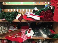 Green garland, red stockings, Santa face decoration, red mesh material, and boxed items on shelves