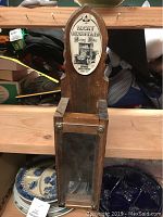 Full view of the wooden Rocky Mountain water dispenser with glass front and latch.