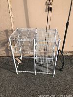 Full view of the white wire rack kitchen caddy showing its overall shape and height outdoors.