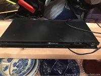 Front and top angled view of the black Sony 3D Blu-ray DVD player showing the top surface, front disc tray, and partial power cord.