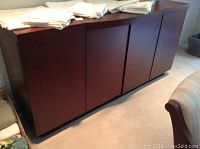 Front view of buffet server showing the four door panels closed and flat top surface with folded linens.