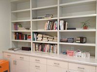 Wide shot of bookshelves filled with books, small stack of CDs and cassette boxes, and some decorative items.