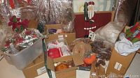 Overview photo showing multiple boxes of holiday decorations including wreath elements, fabric items, and other decorations.