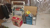 Overview of items in basement showing yard chair, boxes with lamp and appliances