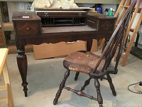 Photo of vintage dark wood secretary desk with pull-out writing shelf and two drawers, spindle legs visible