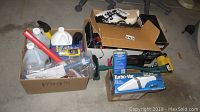 Three cardboard boxes containing various automotive care items including a Turbo Vac, car accessories, and cleaning supplies.