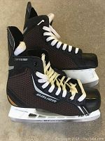 Pair of Bauer Light Speed Pro ice hockey skates side view showing black and dark brown honeycomb pattern with white laces and TUUK blade holders.