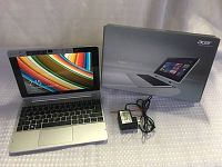 Laptop attached to keyboard dock with box and charger at side