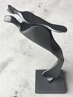 Steel sculpture titled "Father & Child" showing abstract curved forms and smooth finish.
