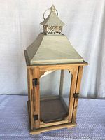 Front view showing wooden frame, latch, and glass panel with metal top