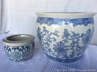 Photo showing both blue and white glazed pottery vessels side by side, highlighting size and decoration.