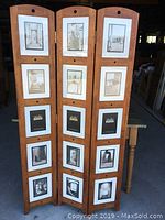 Front of three-panel wooden room divider with multiple photo frames