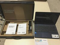 Open box showing ASUS notebook packaging with user manual, warranty card, charger and notebook.
