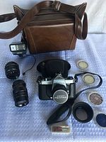 Overview of camera, lenses, filters, flash, remote cable timer, leather cases and bag laid out