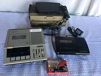 Sony BM-147 cassette transcriber with control buttons and sliders, connected to foot control units, with a cassette tape included