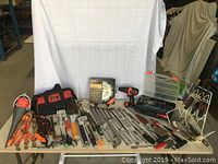 Full view of tools and accessories including power drill, wrenches, tool bags, and assorted hardware.