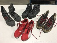 Four men's shoes arranged on a white surface, showing all four pairs included in the lot.