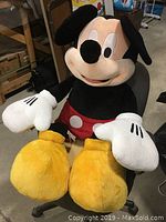 Front view of 40-inch Mickey Mouse plush seated on a chair, showing full body including yellow feet, red shorts, large white gloves, and black ears.