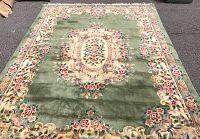Top-down view of full rug showing green field, central floral medallion, floral border
