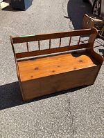 Front view of the vintage pine storage bench showing the hinged lid and spindle backrest.