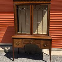 Full front view of two-piece cabinet outdoors against storage door