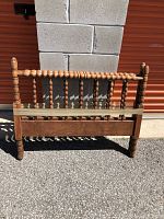 Front view of one wooden single bed end with spool (spindle) rails in vintage condition.