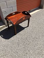 Full view of the butler's coffee table showing the folding sides and wood finish.
