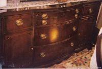 Front view of solid wood side buffet with drawer and cupboard details, brass oval pulls visible.