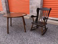 Child's round wooden table and Oak Hill New Hampshire style child's rocker viewed from front showing overall condition and loose leg on table.