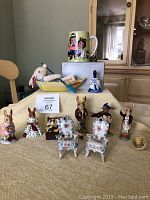Wide view of entire lot showing Bunnykins musical figurine, chairs, bell, cup, baby chick, fabric bunny doll, and multiple Bunnykins ceramic figurines