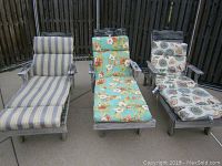 Front view of three wooden lounge chairs outdoors with different patterned cushions: striped, floral turquoise, floral circular design.