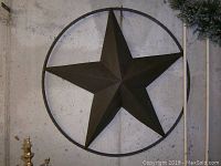 Full view of the dark brown metal star wall art showing shape and size relative to surroundings