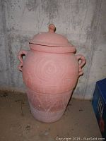 Full view of mauve colored planter showing texture, handles, and lid.