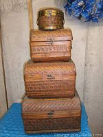 Stack of 4 woven baskets nesting inside each other, showing size progression from 18x13x13 inch largest at bottom to smallest round at top.