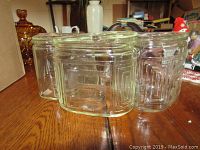 Three clear glass covered dishes grouped together showing square rounded corners and geometric embossed patterns.
