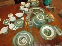 Wide angled photo showing the full collection on a table, confirming the variety of pieces including plates, cups, glasses, salt and pepper shakers, and serving items.