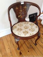 Front full view of antique rounded back wooden chair showing floral painted details on backrest and floral upholstery on seat. Chair legs are Queen Anne style with visible wear and nicks.