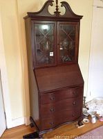 Full front view of secretary desk showing upper cabinet, drop-front desk and lower drawers